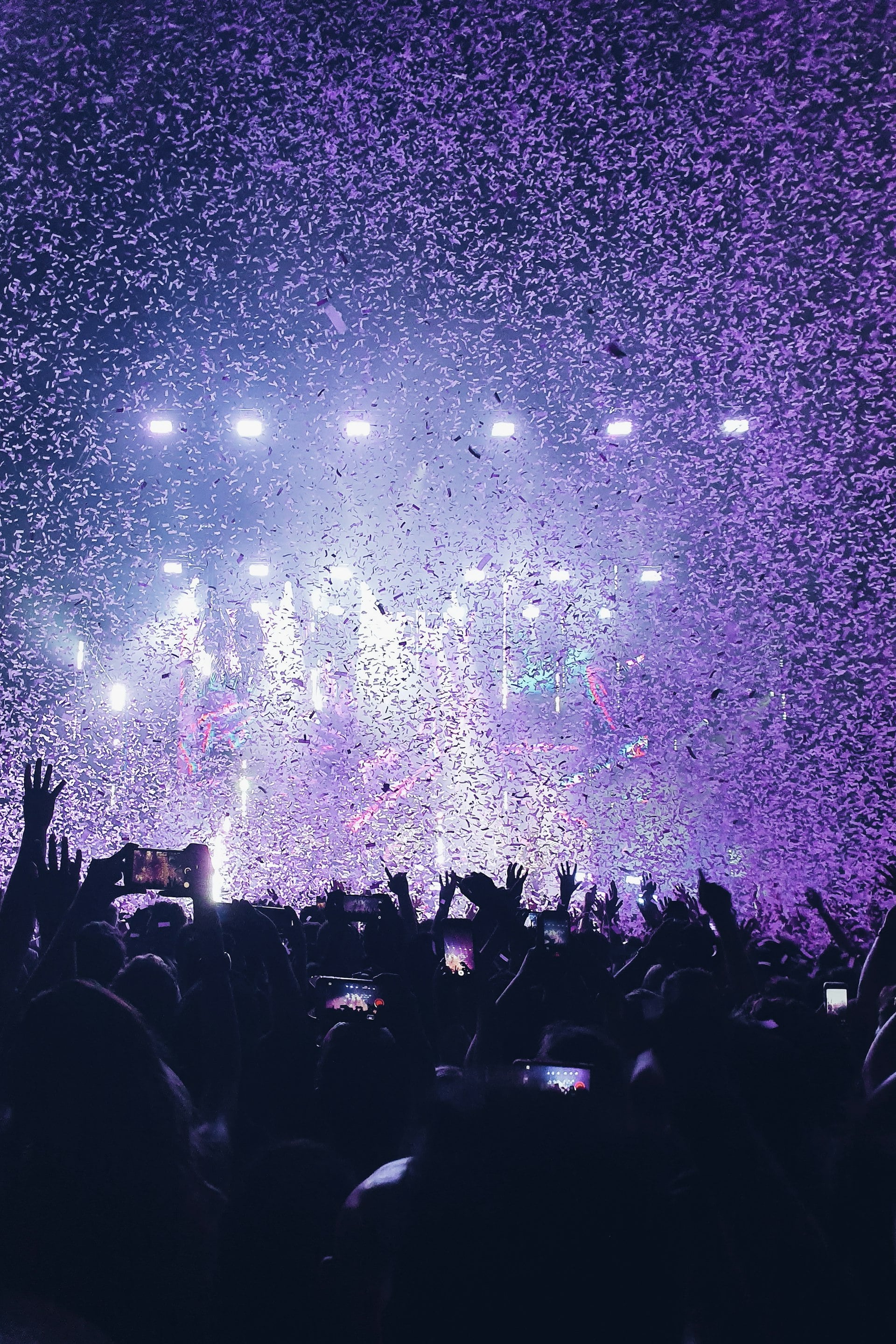 Confetti falling over a crowd under stage lights