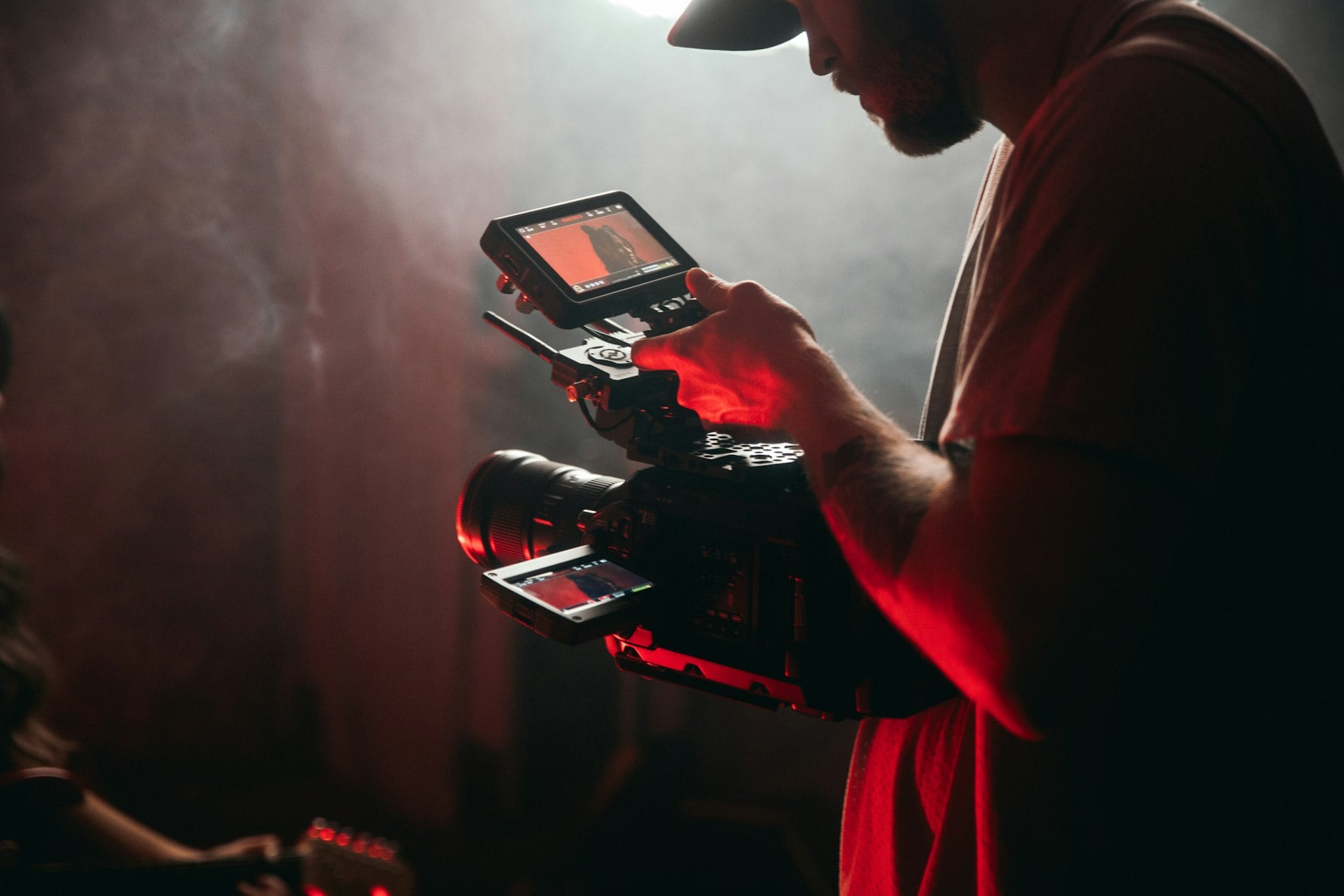 A photographer shooting a portrait against a pink backdrop
