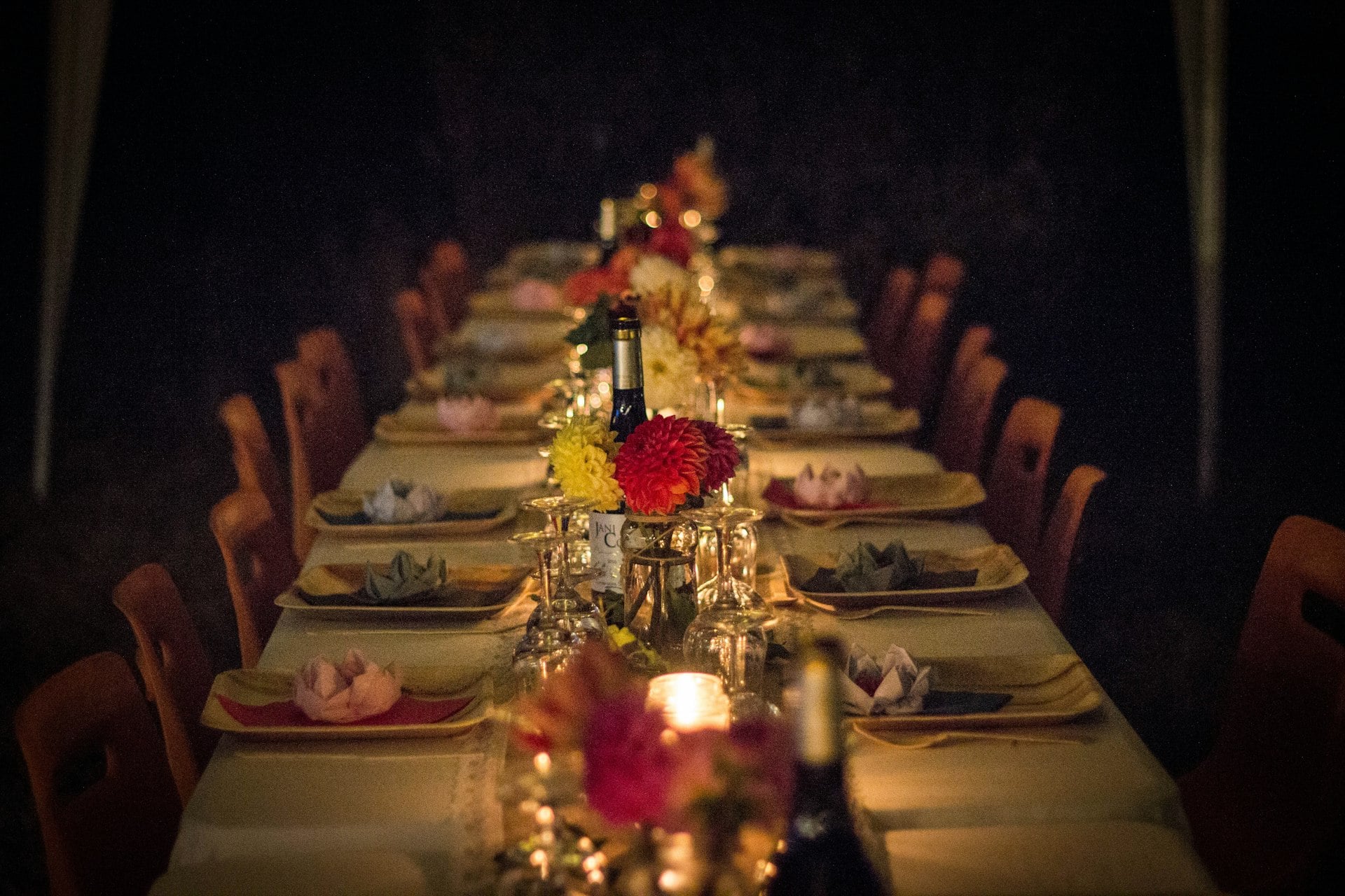 A long dinner table set with flowers and candles