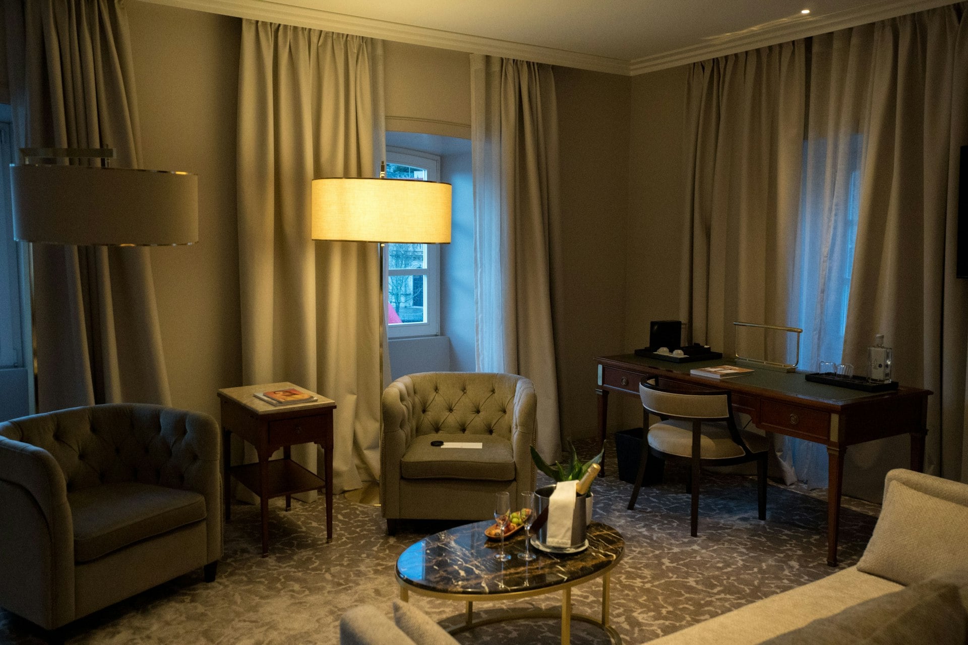 A warmly lit room with armchairs and a desk