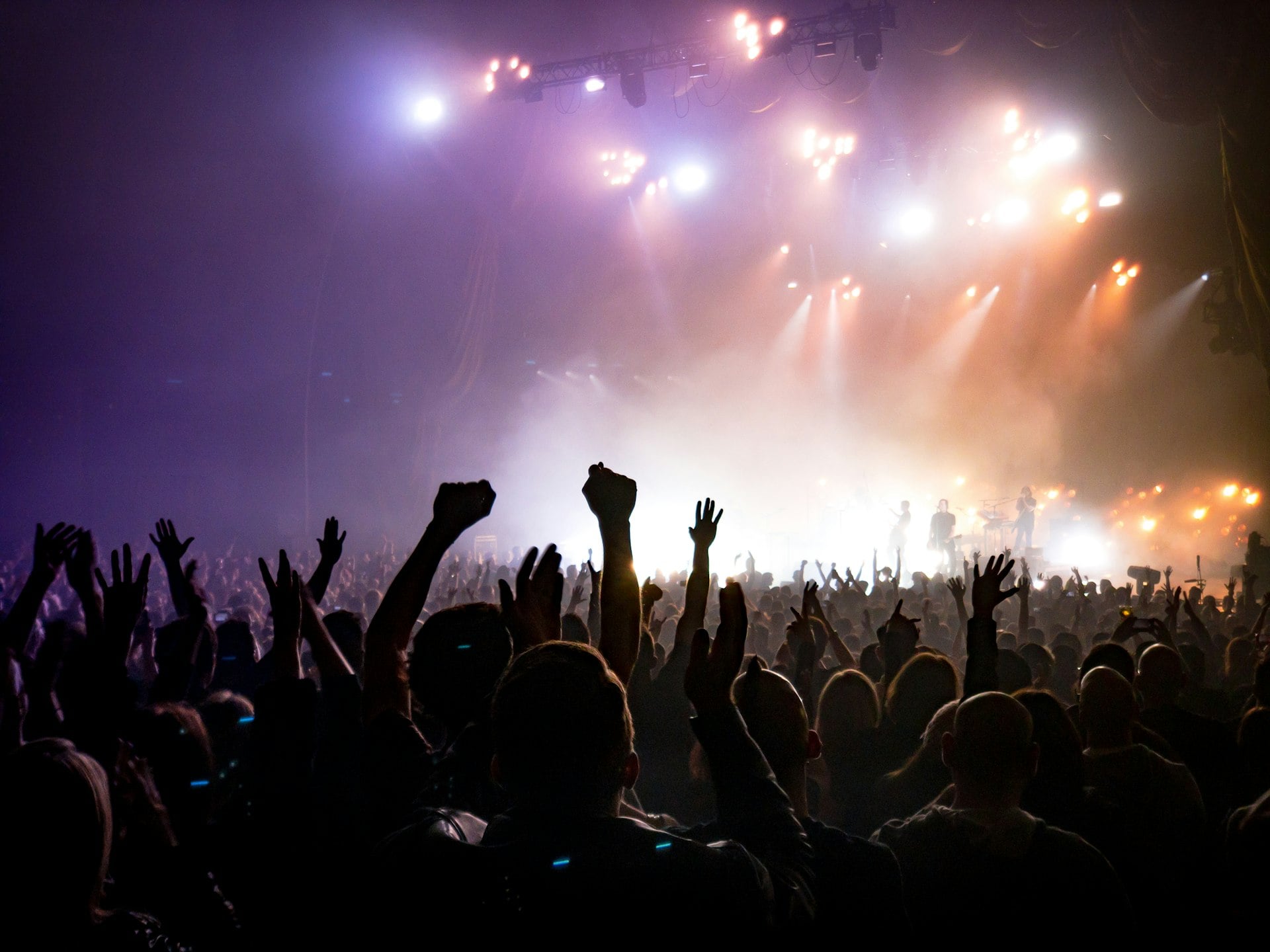 A crowd facing a brightly lit stage